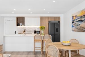 a kitchen and dining room with a table and chairs at Sakara at Marochydore in Maroochydore