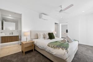 a white bedroom with a bed and a sink at Sakara at Marochydore in Maroochydore +21 photos