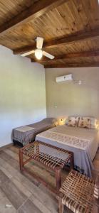 a bedroom with two beds and a wooden ceiling at Aires del Ibera in Colonia Carlos Pellegrini
