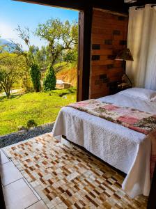 a bedroom with a bed and a large window at Cabana Liberdade in Rio dos Cedros