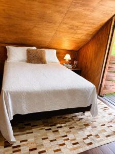 a bedroom with a large bed with a wooden ceiling at Cabana Liberdade in Rio dos Cedros +20 photos