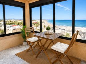 a table and chairs on a balcony with a view of the beach at Chalet a orillas del mar in Torrevieja