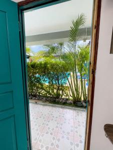 a door leading to a patio with palm trees at Pacific Coast Hotel in Playa Bonita Village