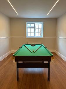 a pool table in a room with a window at Cavendish Hotel in High Wycombe