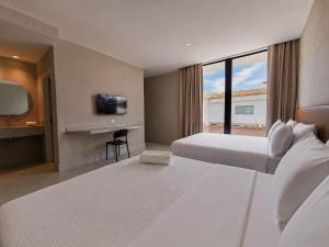 a hotel room with two beds and a television at Sereno Hotel in Cabo Frio