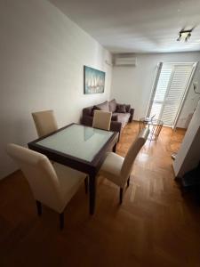 a living room with a table and chairs and a couch at Apartment Biserka in Cavtat