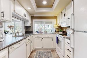 a kitchen with white cabinets and a large window at Anchorage 7473 in Hilton Head Island +16 photos