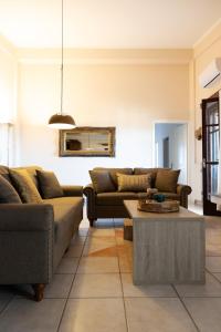 a living room with two couches and a coffee table at TheA Upper Blue in Kyparissia