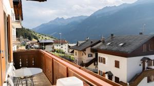 a balcony with a table and a view of mountains at Alpine Living Apartments in Bormio