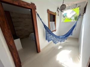 a room with a blue hammock hanging on the wall at Pousada Coqueiro do Caitá in Morro de São Paulo