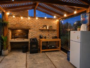 an outdoor kitchen with a brick wall and a refrigerator at Aires del Ibera in Colonia Carlos Pellegrini
