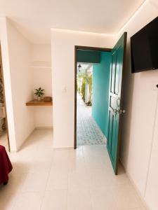 a hallway with a blue door and a tile floor at Pacific Coast Hotel in Playa Bonita Village
