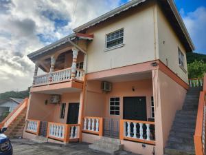 a house with a staircase in front of it at K&C RENTALs in Mount Gay
