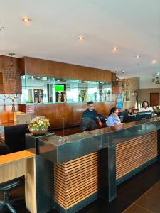 people sitting at a bar in a restaurant at Flat com vista para o mar - apto 1605 in Natal