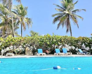 a swimming pool with blue chairs and palm trees at Kasa Balcony View for 2 in San Juan