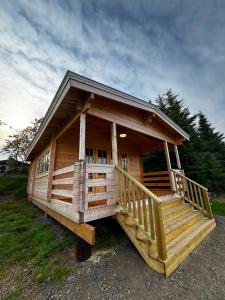 a large wooden cabin with a large porch at Hotel Stadarborg in Breiðdalsvík