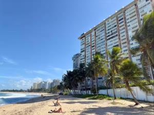 a beach with palm trees and a building at Kasa Balcony View for 2 in San Juan