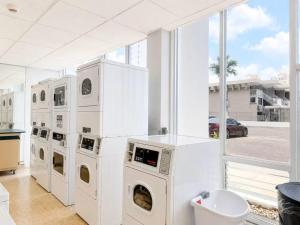 a laundry room with white appliances and a large window at Kasa Balcony View for 2 in San Juan