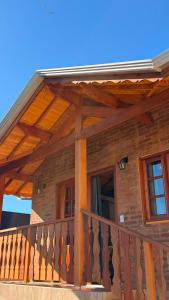 a wooden balcony of a log cabin with a railing at Apartamentos da Jo in Monte Verde