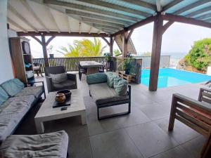 a patio with couches and a table and a pool at Villa Hill-Sea in Saint Martin