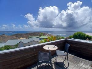 a balcony with a table and chairs and a view of the ocean at Villa Hill-Sea in Saint Martin