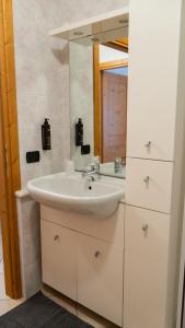 a bathroom with a sink and a mirror at Alpine Living Apartments in Bormio +58 photos