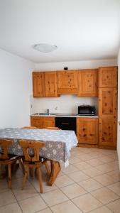 a kitchen with a table and wooden cabinets at Alpine Living Apartments in Bormio