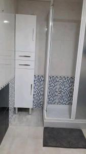 a bathroom with a shower and white cabinets at Arena Maipú in Maipú