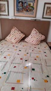a bed with two pillows on top of it at Arena Maipú in Maipú