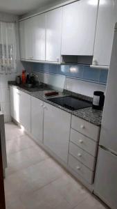 a kitchen with white cabinets and a sink at Arena Maipú in Maipú