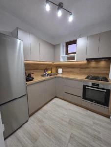a kitchen with white cabinets and a stainless steel refrigerator at Gashi Home in Prizren
