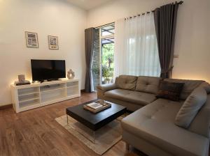 a living room with a couch and a tv at Zen Cove Villa - 5-Min Walk to Zen Beach, Srithanu in Haad Chao Phao