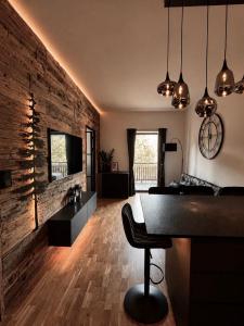 a living room with a piano and a brick wall at Mountain Loft Nassfeld in Tröpolach