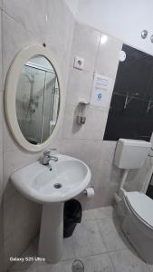 a bathroom with a sink and a mirror and a toilet at Residencial Raiar in Mindelo +10 photos