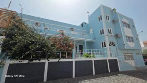 a blue house with a fence in front of it at Residencial Raiar in Mindelo