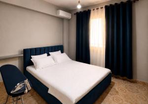 a bedroom with a bed and a chair and a window at Ledi’s Home in Borsh