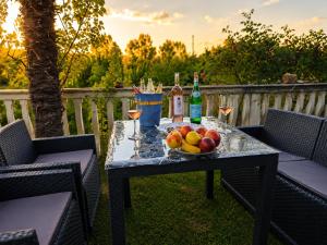 a table with a bowl of fruit and a bottle of wine at Kiki - Emerald River Suite with Private Gardens in Čapljina