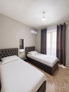 a hotel room with two beds and a window at Ledi’s Home in Borsh
