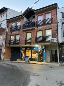a brick building with windows and balconies on a street at Gashi Home in Prizren