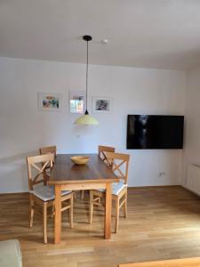 a dining room with a table and chairs and a tv at Stranach Appartements in Sankt Michael im Lungau
