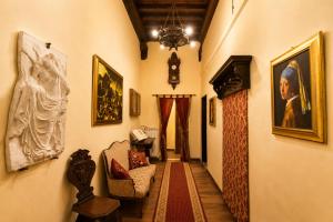 a hallway with paintings and art on the walls at All'Ombra della Torre a due passi da Piazza del Campo in Siena