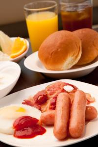 two plates of breakfast food with eggs sausage and pancakes at Citadines Central Shinjuku Tokyo in Tokyo