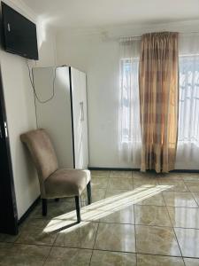 a living room with a chair and a television at Alwaba guest house in Mthatha