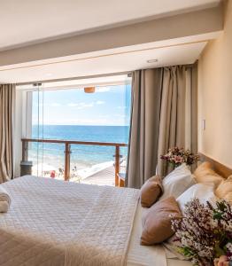 a bedroom with a bed with a view of the ocean at Pousada Manhã Dourada in Morro de São Paulo