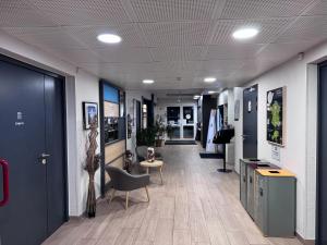 an office hallway with a chair and a table at B&B HOTEL Auxerre Monéteau in Monéteau