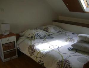 a bedroom with a bed with a white comforter at penty Broceliande 3 personnes in Guilliers