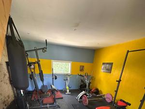 a gym with several exercise equipment in a room at penty Broceliande 3 personnes in Guilliers