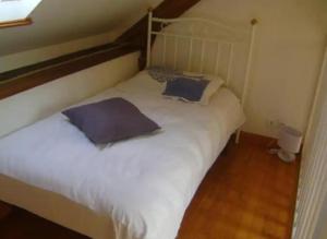 a bedroom with a white bed with two pillows at penty Broceliande 3 personnes in Guilliers
