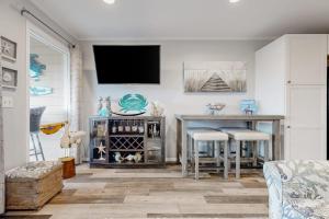 a living room with a table and a tv on the wall at HH Beach & Tennis 319B in Hilton Head Island