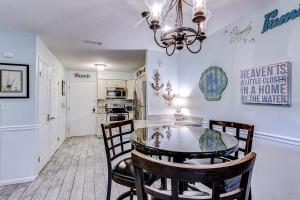 a dining room with a table and chairs and a kitchen at Fiddlers Cove 18B in Hilton Head Island